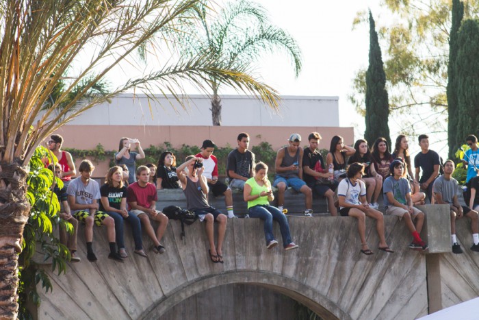 Students perched on a ledge as they enjoy Jack Johnson's performance.