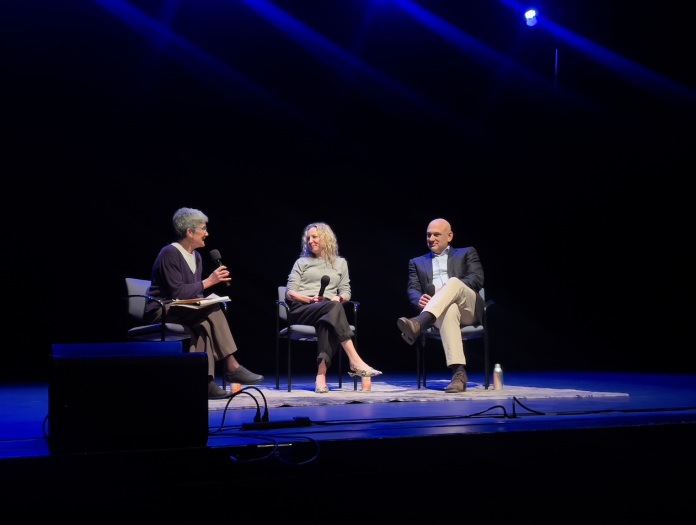 Three people sitting and chatting on a stage
